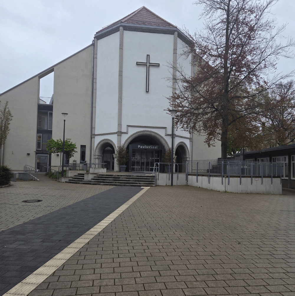 Exterior view of Destined Winners Ministry International church premises featuring a modern building with a large cross, welcoming entrance, and open courtyard.